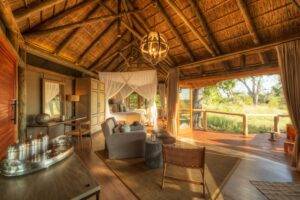 Bedroom and guest area of the accommodation at Camp Moremi