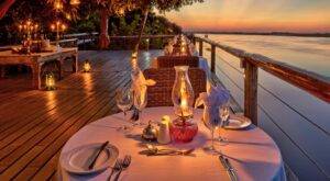 Dining set up on the deck overlooking the river during sunset at Chobe Game Lodge in Botswana