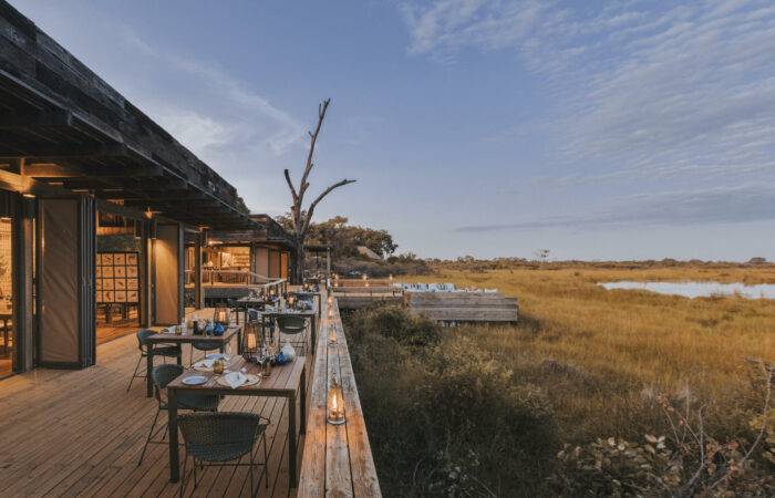 Outdoor dining deck overlooking the bush at Vumbura Plains Camp in Botswana