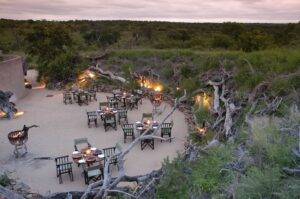dining set up with table and chairs outside at Sabi Sabi Earth Lodge in Kruger Park