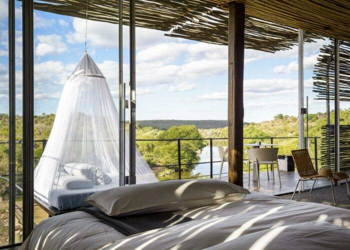 bedroom interior with great views of the bush and lake from the window at Singita Lebombo Lodge
